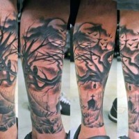 Tatuaje en la pierna, cementerio con árbol grueso seco y cuervos