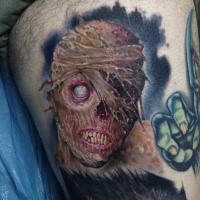 Creepy colored horror style thigh tattoo of monster face