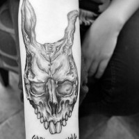 Creepy cult like black ink bunny skull with lettering on arm