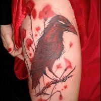 Tatuaje en el muslo,  cuervo asombroso en la rama, colores negro y rojo