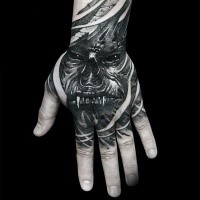 Creepy horror style black ink hand tattoo of monster face