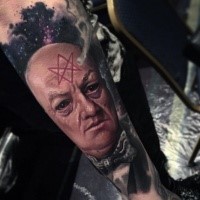 Creepy looking arm tattoo of mystical man with symbol