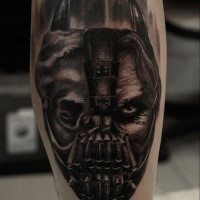 Creepy looking black ink leg tattoo of half Bane half Batman