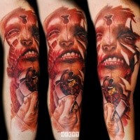 Creepy looking colored arm tattoo of mystical demonic face