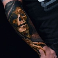 Creepy looking colored arm tattoo of human skeleton with hood