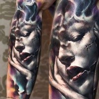 Creepy looking colored arm tattoo of woman portrait