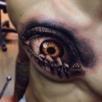 Creepy looking colored chest tattoo of human eye with hand
