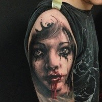 Creepy looking colored shoulder tattoo of bloody girl portrait