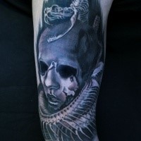 Creepy looking colored shoulder tattoo of monster clown with snake skeleton