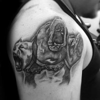Creepy looking colored shoulder tattoo of Cerberus dog
