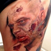 Creepy looking colored thigh tattoo of zombie man face