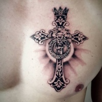 Croce con testa di leone tatuata sul petto