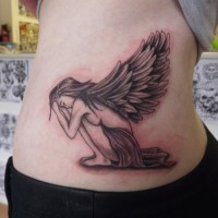 bel angelo ragazza piangendo seduta piegata tatuaggio su costolette