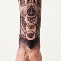 Cult like black and white skull with planets tattoo on wrist