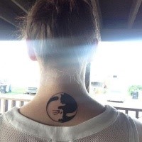 Curled black and white cat Asian Yin Yang symbol shaped tattoo on lady's upper back