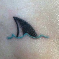 Tatuaje en el tobillo, aleta de tiburón diminuta en olas
