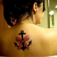 Tatuaje en la espalda,
ancla simple negra con lazo rosa