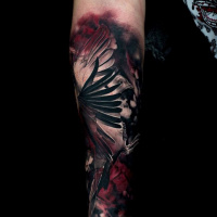 Cute black and red bird tattoo on forearm