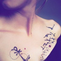 Tatuaje en el pecho, 
ancla fina elegante con bandada de aves
