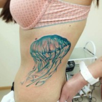 Tatuaje en las costillas,
medusa ancha de color azul claro