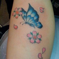 carina farfalla blu tatuaggio con fiori su braccio