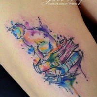 Cute cat sitting on pale of thick books rainbow colored thigh tattoo in watercolor style by Javi Wolf