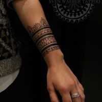 Simpatici ornamenti floreali in inchiostro nero tatuati sul braccio