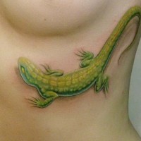 Tatuaje en las costillas,
lagarto bonito verde