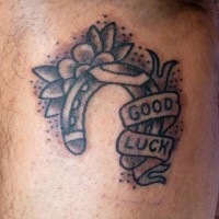 Cute horseshoe for good luck and flowers tattoo