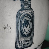 carina piccola bottiglia di profumi con scritto tatuaggio su schiena