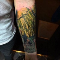 Cute multicolored man with dog in old forest tattoo on arm