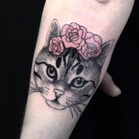 Tatuagem de antebraço pintada e colorida de cabeça de gato com flores rosa