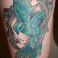 Tatuaje de ave linda verde  en el muslo