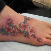 bei ramo con fiori rosa tatuaggio su piede di ragazza