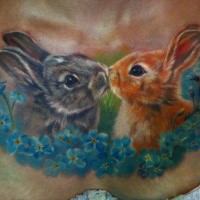 Cute realism style colored kissing rabbits tattoo on chest with blue flowers