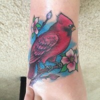 Tatuaje en el pie,
pájaro rojo atractivo  en la ramita