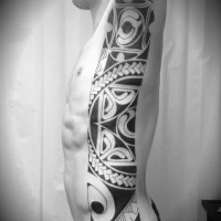 Dark black and white tribal style tattoo on side