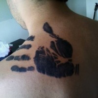 Tatuaje en el hombro, huella de mano humana, tinta negra