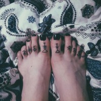 Dunkle schwarze kleine Runen Tattoo an Zehen