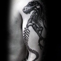 Dark black ink typical shoulder tattoo of dinosaur skeleton