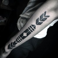 Dark black thick stylized arrow in tribal style arm tattoo