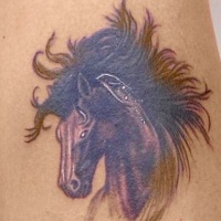 Dark horse head with a lush mane tattoo