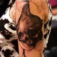 Tatuaje  de cráneo negro con hojas blancas en el brazo