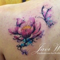 Delicate pink lotus flower and flying butterfly colored tattoo on shoulder blade by Javi Wolf in watercolor style