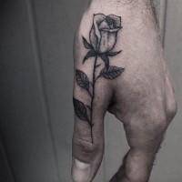 Delicate tender rose black and white tattoo on thumb