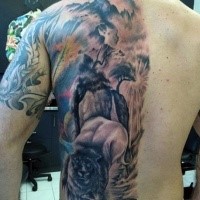 Detailed black and gray style back tattoo of lion head with tree and mountains