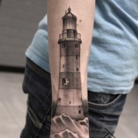 Detailed black ink arm tattoo of lighthouse