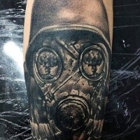 Detailliertes schwarzes Unterarm Tattoo mit der gebrochenen Gasmaske