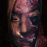 Detailed creepy looking leg tattoo of bloody monster face