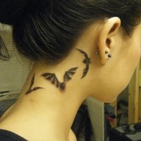 Detailed flying bats small size tattoo on lady's neck